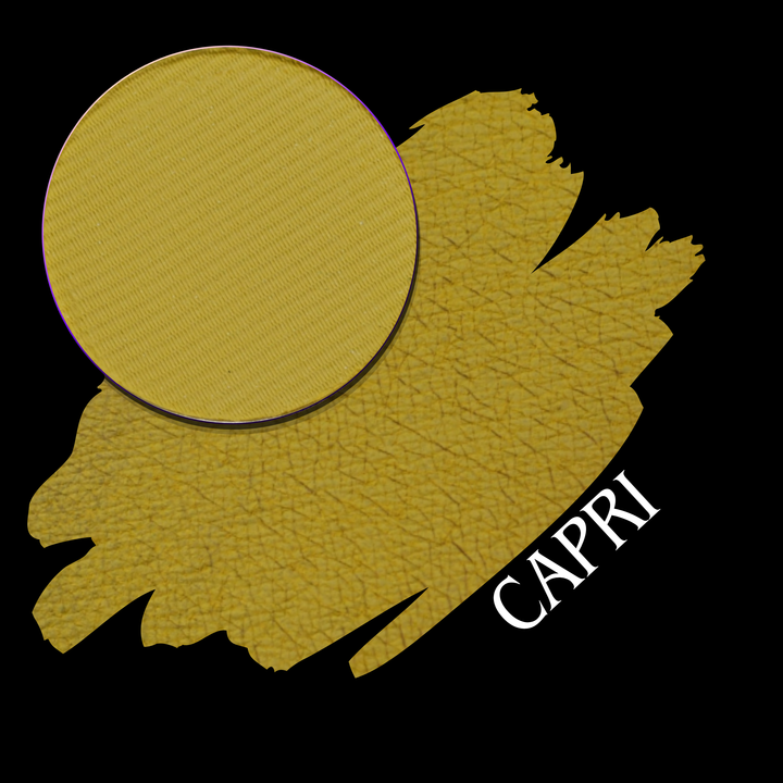 A textured yellow gold makeup swatch with a circular eyeshadow pan, overlaid on a black background with the word 'CAPRI' in white text.