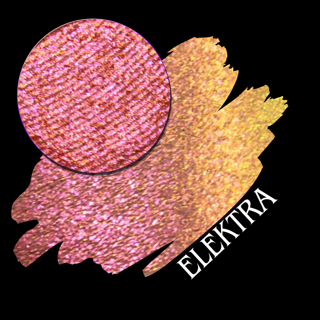 A round eyeshadow pan labeled 'ELEKTRA' made by Devinah Cosmetics, placed over a large crescent moon swatch of the same shimmering shifty duochrome multichrome eyeshadow on skin. The eyeshadow has a shift between colors green, gold, pink.