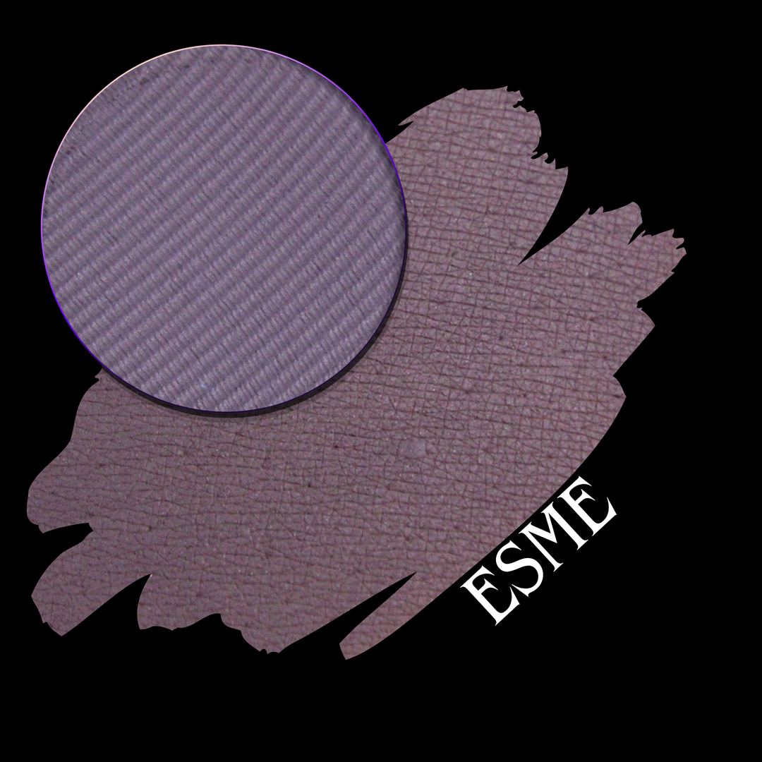 An eyeshadow swatch in a muted mauve-purple shade, shown with a circular eyeshadow pan and the letters 'ESME' in white on a black background