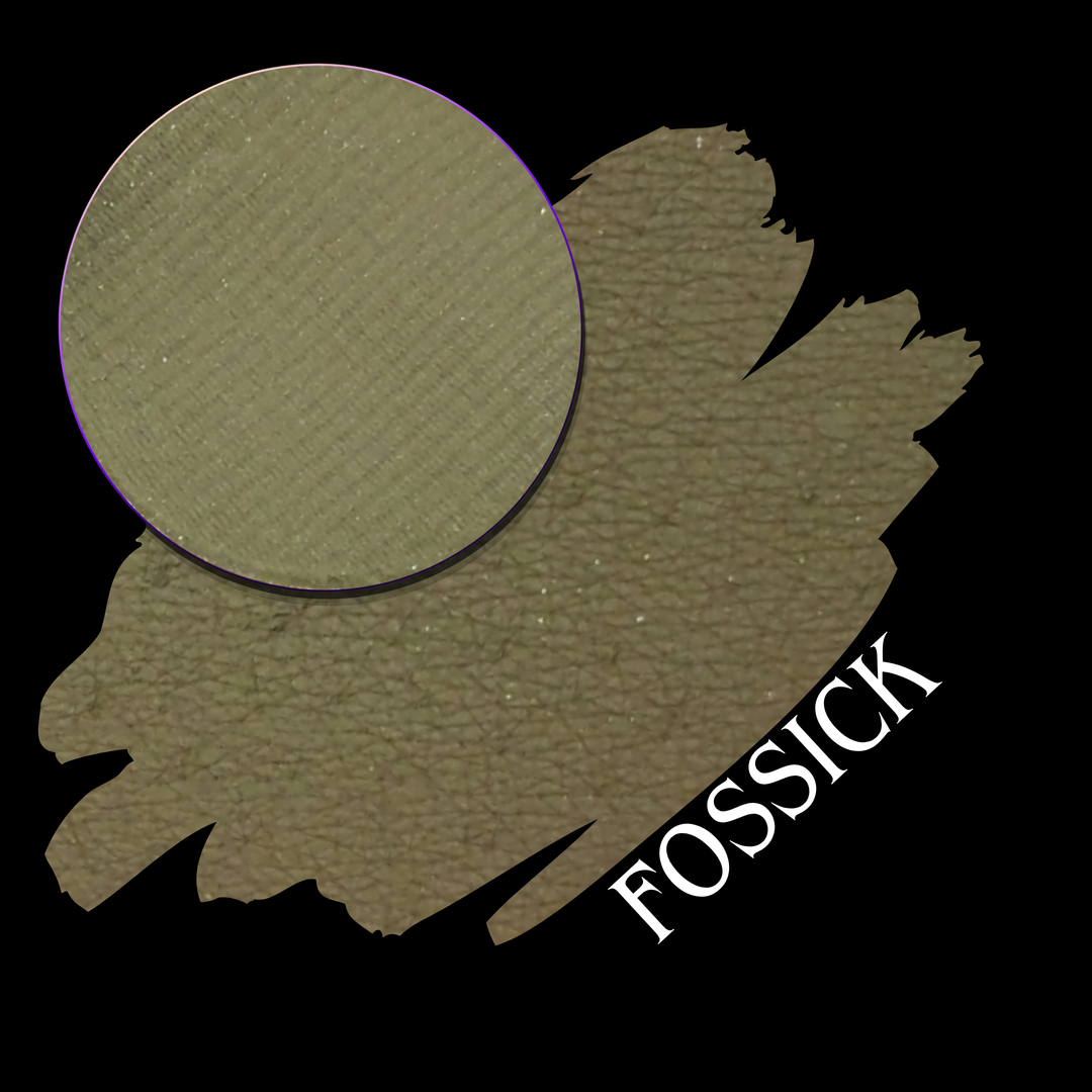 An eyeshadow swatch in the shade 'Fossick' shown with a circular close-up of the eyeshadow pan on a black background, with the shade name 'FOSSICK' printed in white on a black background