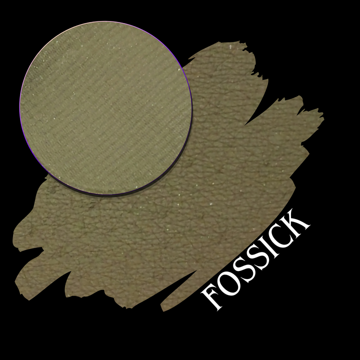 An eyeshadow swatch in the shade 'Fossick' shown with a circular close-up of the eyeshadow pan on a black background, with the shade name 'FOSSICK' printed in white on a black background