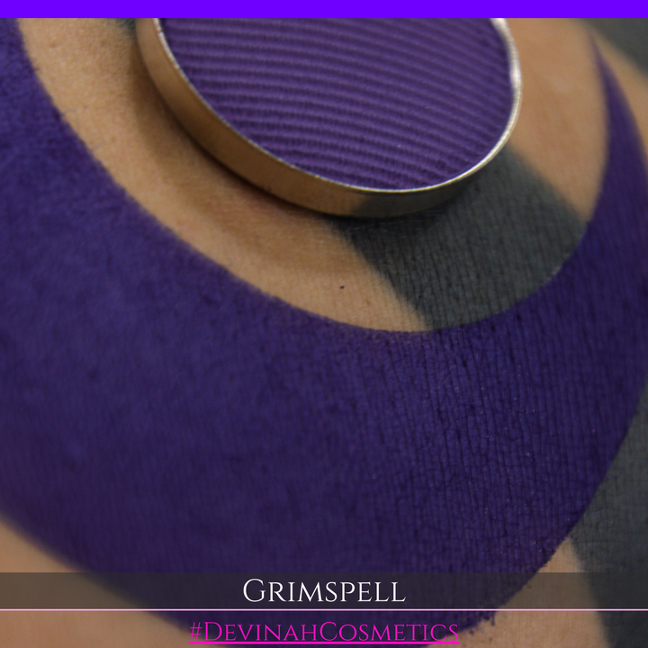 A close-up of a purple matte eyeshadow swatch and the eyeshadow pan. The text 'GRIMSPELL' and '#DEVINAHCosmetics' are displayed at the bottom.