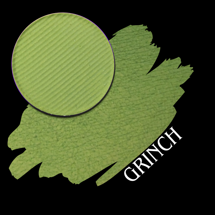 A green circular eyeshadow pan shown with a close-up large green swatch on a black background, with the word 'GRINCH' in white text.