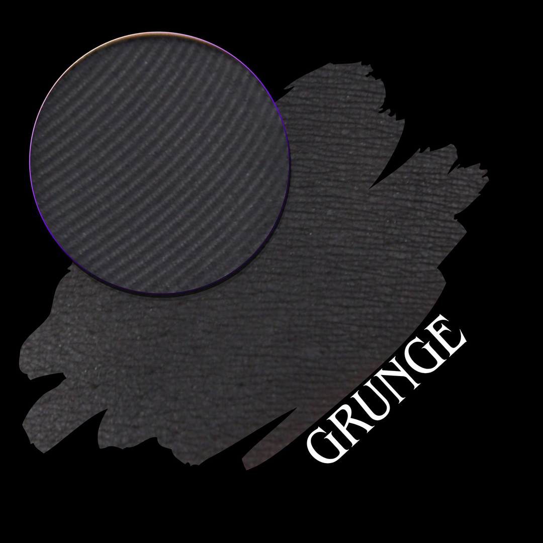 A charcoal gray and blackl eyeshadow swatch with a circular close-up makeup eyeshadow pan, labeled with the word 'GRUNGE' in white text on a black background.