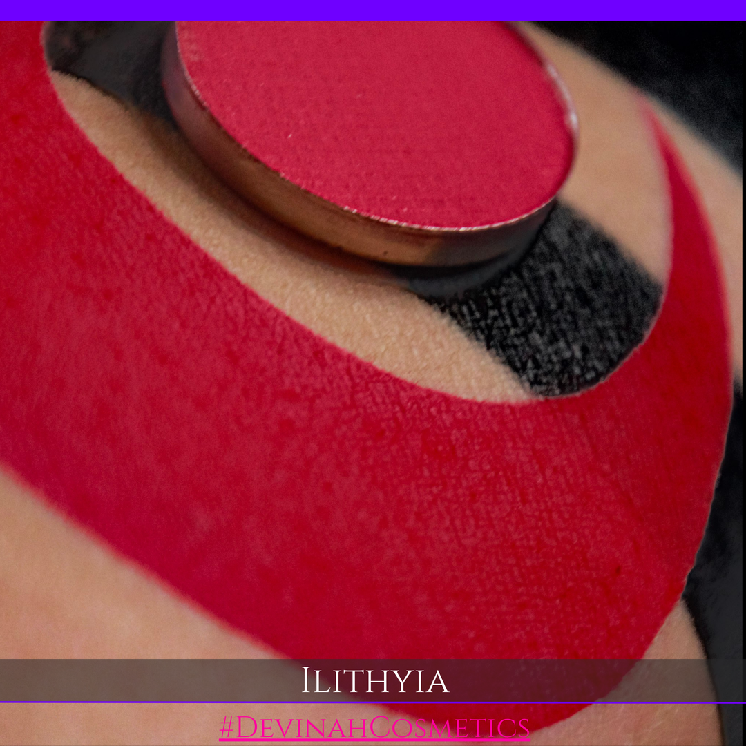 A close-up of a  dramatic red berry eye shadow pan and swatch. The name 'ILITHYIA' and hashtag '#DEVINAH COSMETICS' are displayed at the bottom.