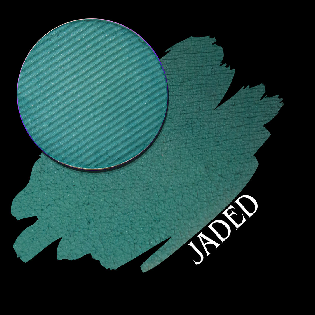 A teal eyeshadow makeup pan shown with a swatch and the name 'JADED' in white text on a black background.