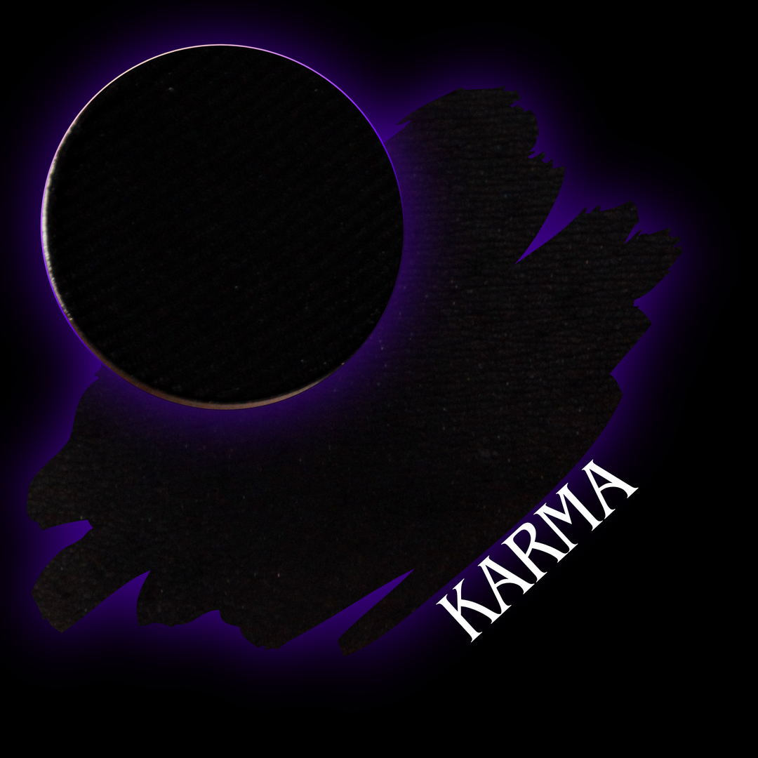 A black circular cosmetic pan or eyeshadow palette with a purple glow and the word 'KARMA' in white text on a black background.