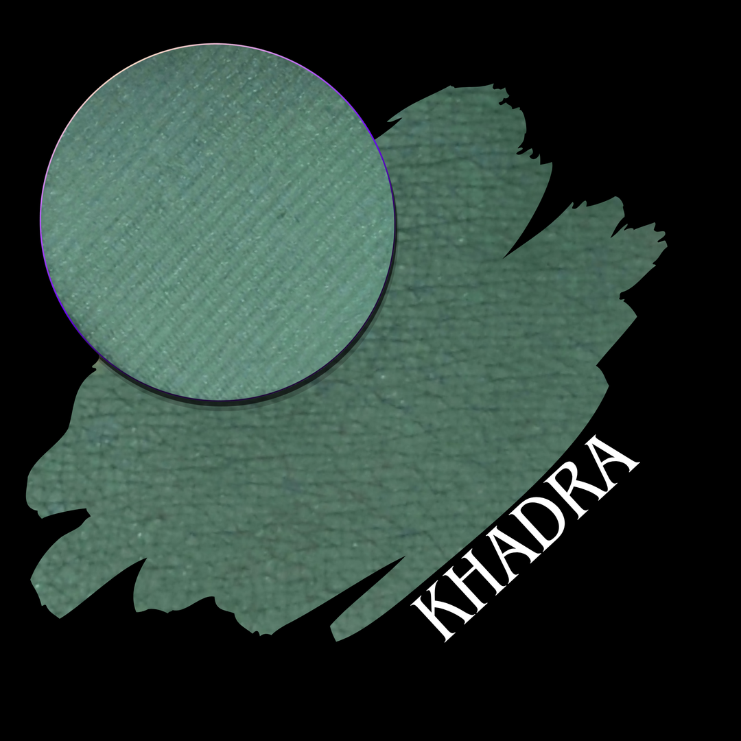 A textured green eyeshadow swatch with a circular makeup eyeshadow pan and the name 'KHADRA' written in white text, set against a solid black background.