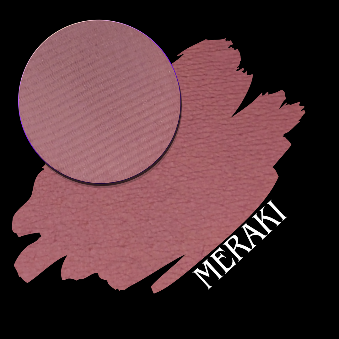 A makeup swatch showing a dusty rose pink color with a circular makeup eyeshadow pan on top, labeled 'MERAKI' on a black background.
