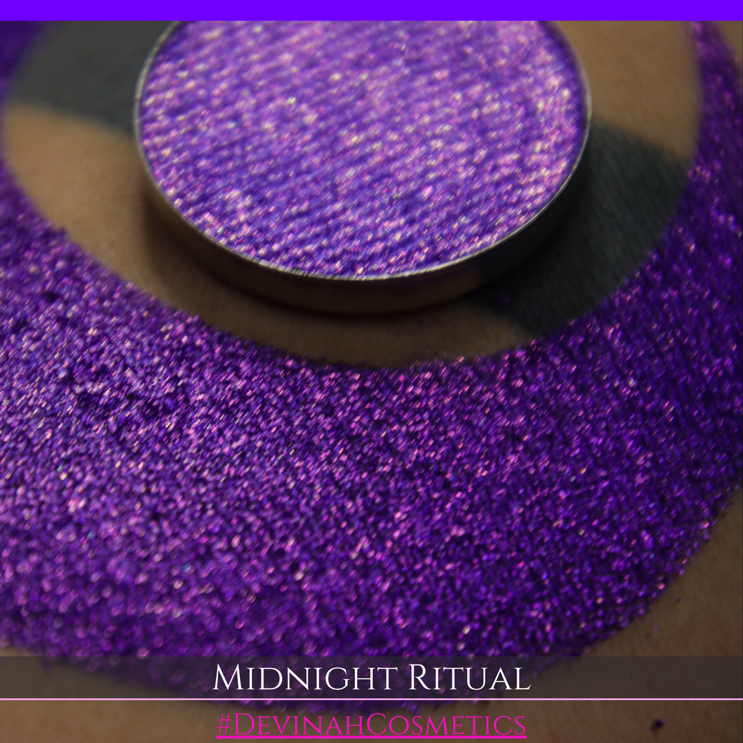 A close-up of a large glittery purple makeup swatch and a matching round pan of purple eyeshadow. Text at the bottom reads 'MIDNIGHT RITUAL' and '#DEVINAHCOSMETICS'.