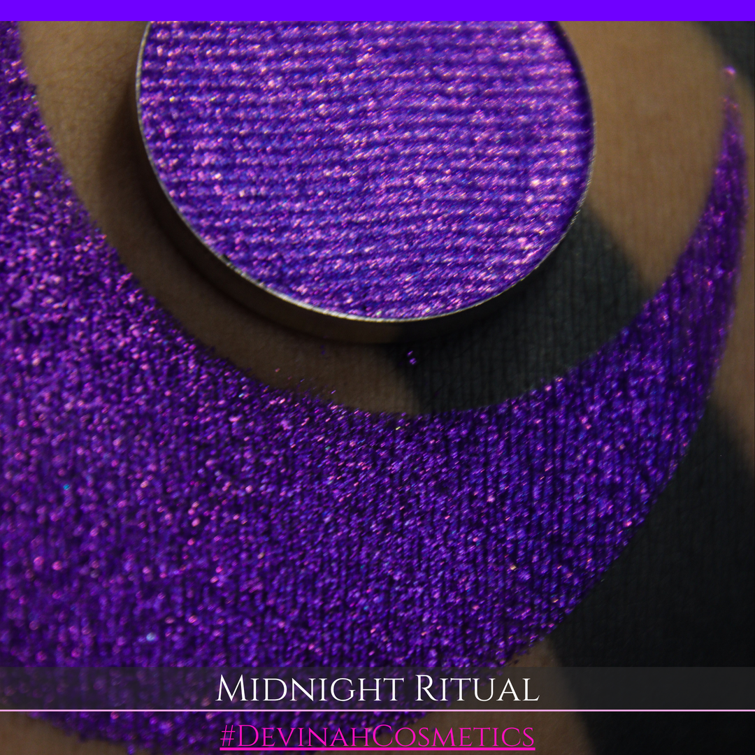 A close-up of a large glittery purple makeup swatch and a matching round pan of purple eyeshadow. Text at the bottom reads 'MIDNIGHT RITUAL' and '#DEVINAHCOSMETICS'.