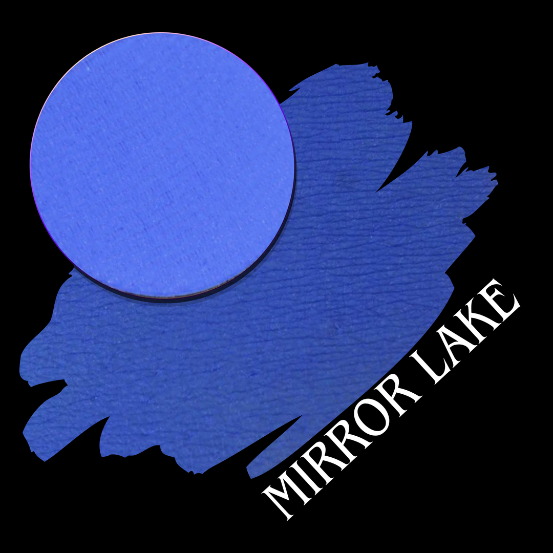 A blue circular eyeshadow makeup pan with a swatch on a black background, with the text 'MIRROR LAKE' in white along the lower right.