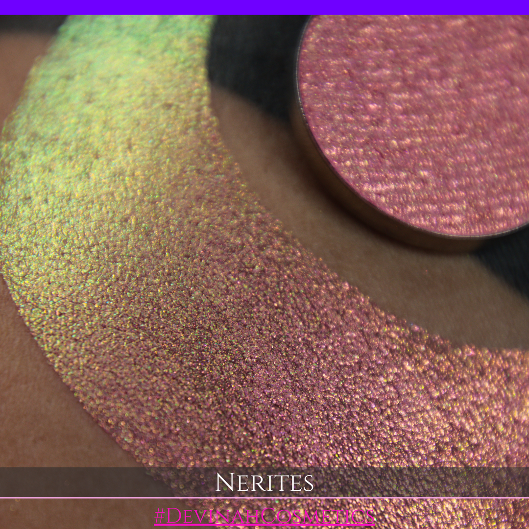 A round eyeshadow pan labeled 'NERITES' made by Devinah Cosmetics, placed over a large crescent moon swatch of the same shimmering multichrome eyeshadow on skin. The eyeshadow has a shimmer sparkle finish shifting between colors pink, yellow, gold, green.