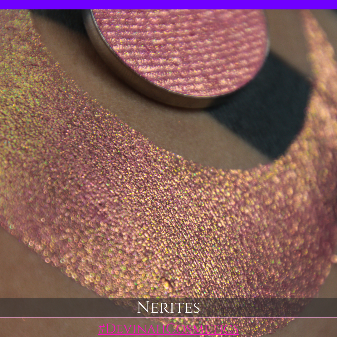A round eyeshadow pan labeled 'NERITES' made by Devinah Cosmetics, placed over a large crescent moon swatch of the same shimmering multichrome eyeshadow on skin. The eyeshadow has a shimmer sparkle finish shifting between colors pink, yellow, gold, green.