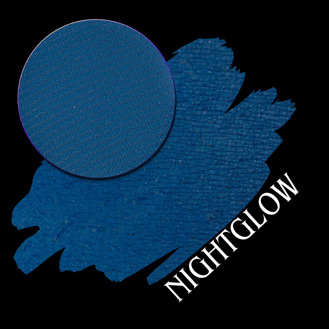 eyeshadow makeup pan over a swatch of a deep blue matte eyeshadow swatch with the name nightglow in white font in the lower corner