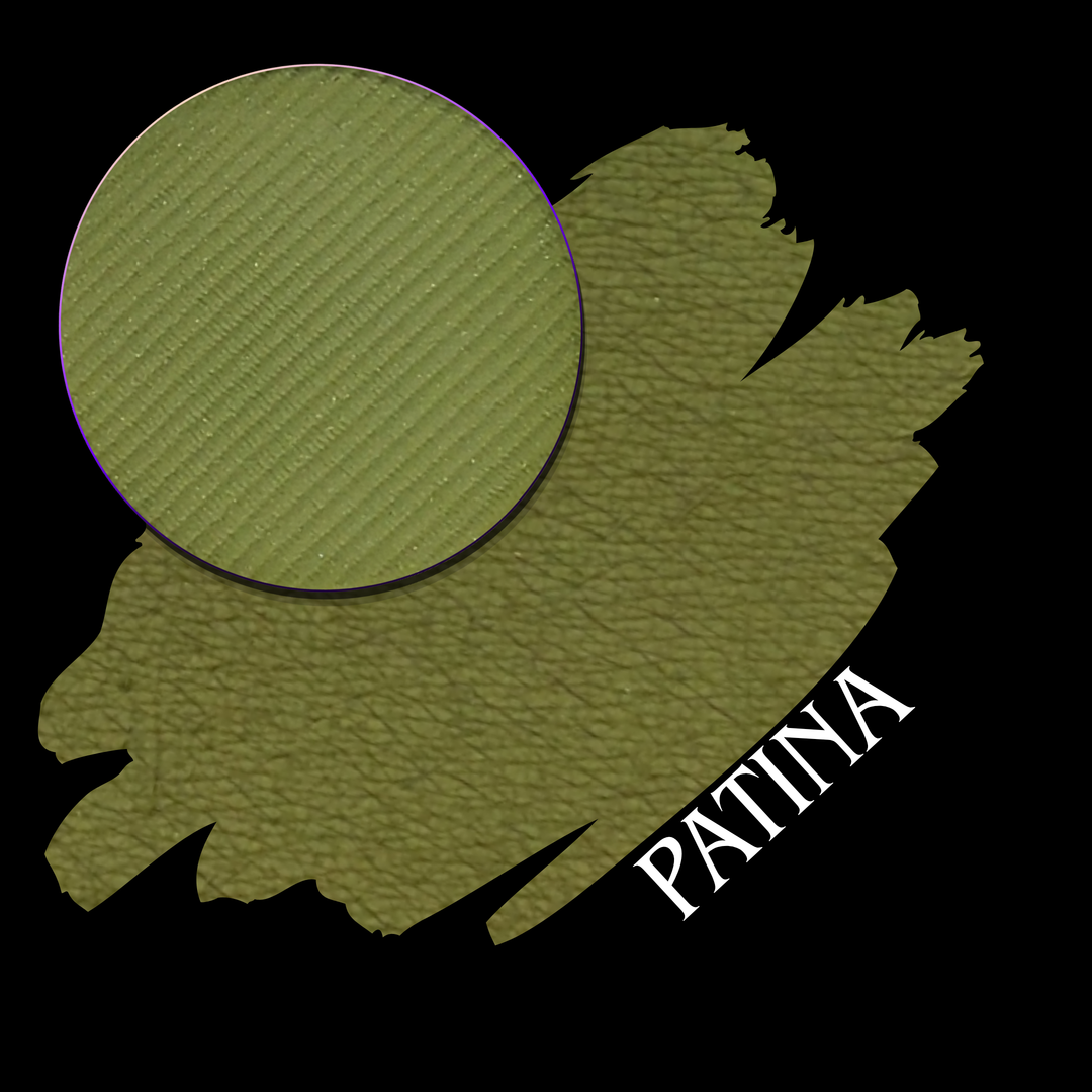 A textured olive green patina finish swatch with a circular eyeshadow makeup pan of matte pigment and the word 'PATINA' in white text, shown on a black background.