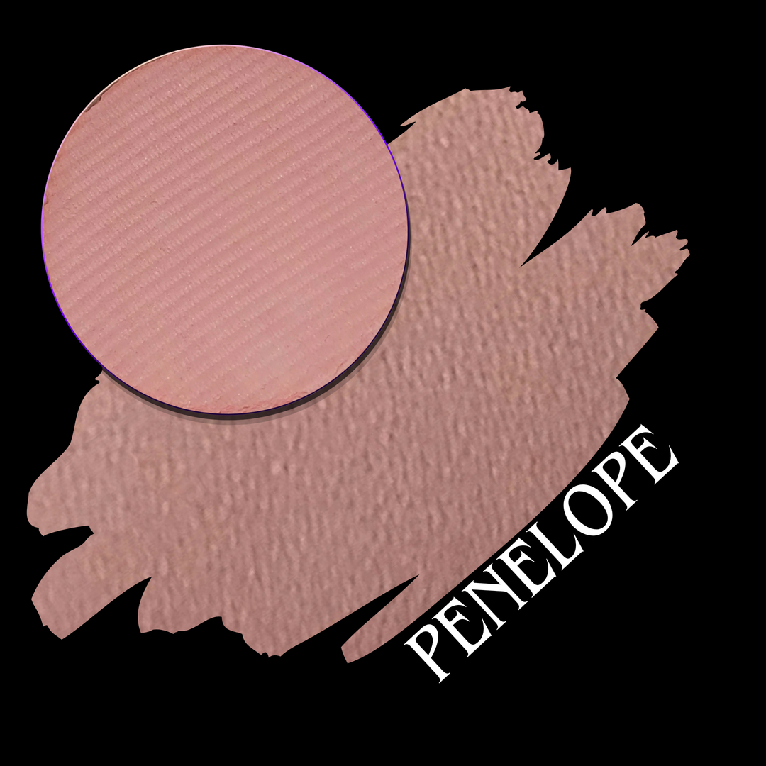 A makeup color swatch showing a dusty rose pink swatch with a circular makeup eyeshadow pan of a pressed matte pigment, labeled 'PENELOPE' on a black background.