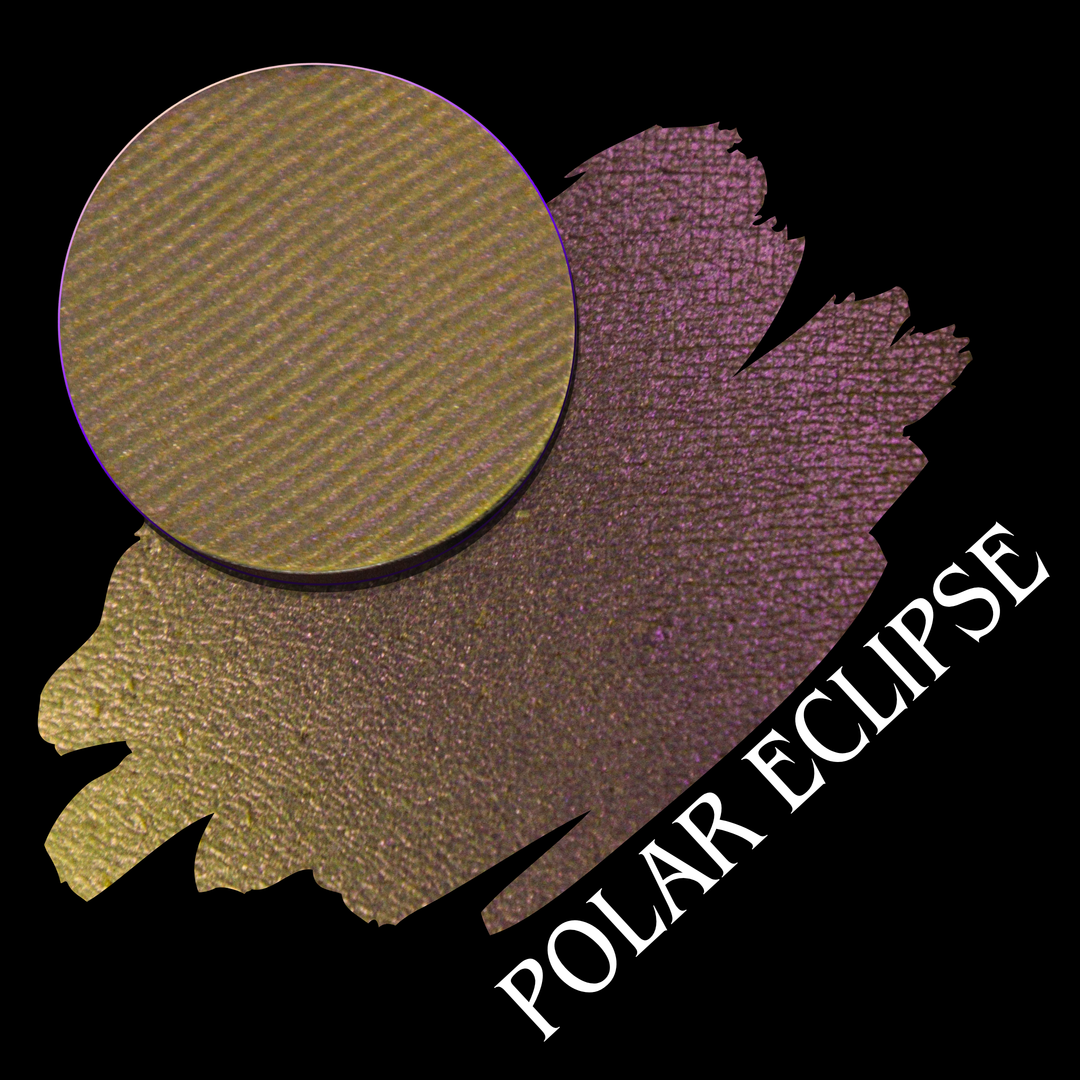 An eyeshadow pan shown above a swatch on a black background, with the text 'POLAR ECLIPSE' in white. The product color shifts from yellow to pink with a shimmering finish, hand made by Devinah Cosmetics.