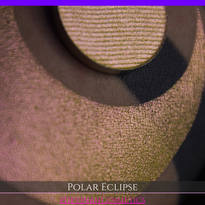 A close-up of a swatch and a circular  shimmering eyeshadow pan in a yellow-to-iridescent pink tone. Text at the bottom reads 'POLAR ECLIPSE' and '#DEVINAH Cosmetics'.