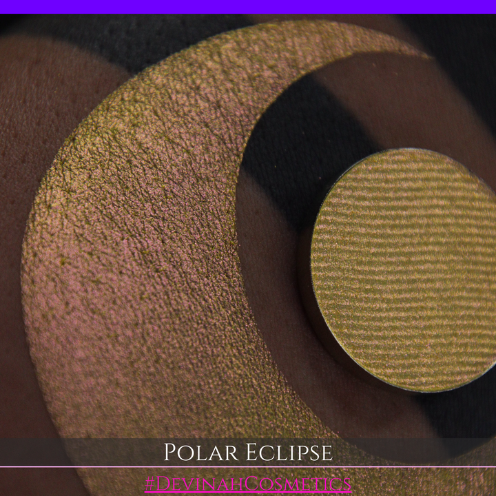 A close-up of a swatch and a circular  shimmering eyeshadow pan in a yellow-to-iridescent pink tone. Text at the bottom reads 'POLAR ECLIPSE' and '#DEVINAH Cosmetics'.
