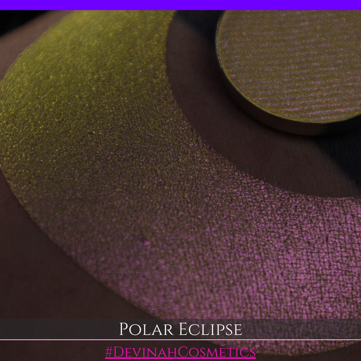 A close-up of a swatch and a circular  shimmering eyeshadow pan in a yellow-to-iridescent pink tone. Text at the bottom reads 'POLAR ECLIPSE' and '#DEVINAH Cosmetics'.