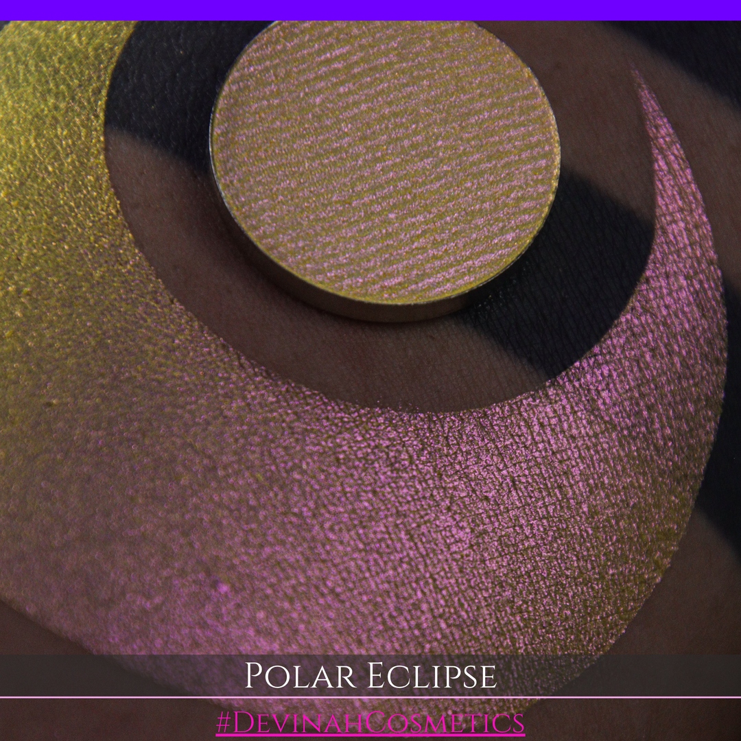 A close-up of a swatch and a circular  shimmering eyeshadow pan in a yellow-to-iridescent pink tone. Text at the bottom reads 'POLAR ECLIPSE' and '#DEVINAH Cosmetics'.