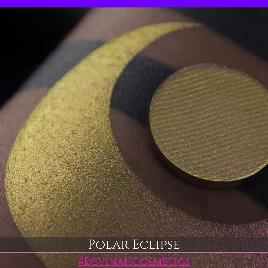 A close-up of a swatch and a circular  shimmering eyeshadow pan in a yellow-to-iridescent pink tone. Text at the bottom reads 'POLAR ECLIPSE' and '#DEVINAH Cosmetics'.