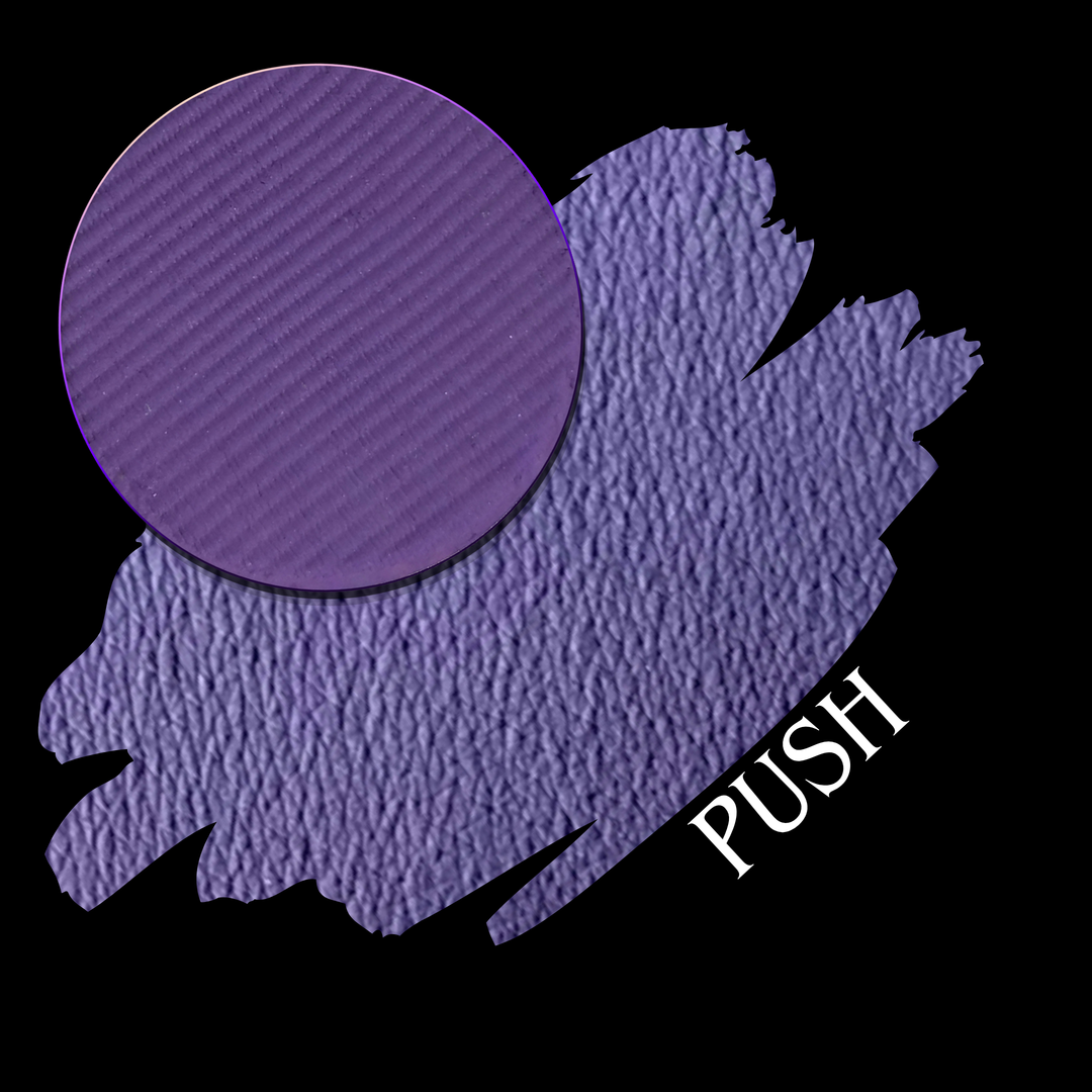 A textured purple cosmetic swatch with a circular close-up of the eyeshadow pan and the word 'PUSH' in white text, shown on a black background.
