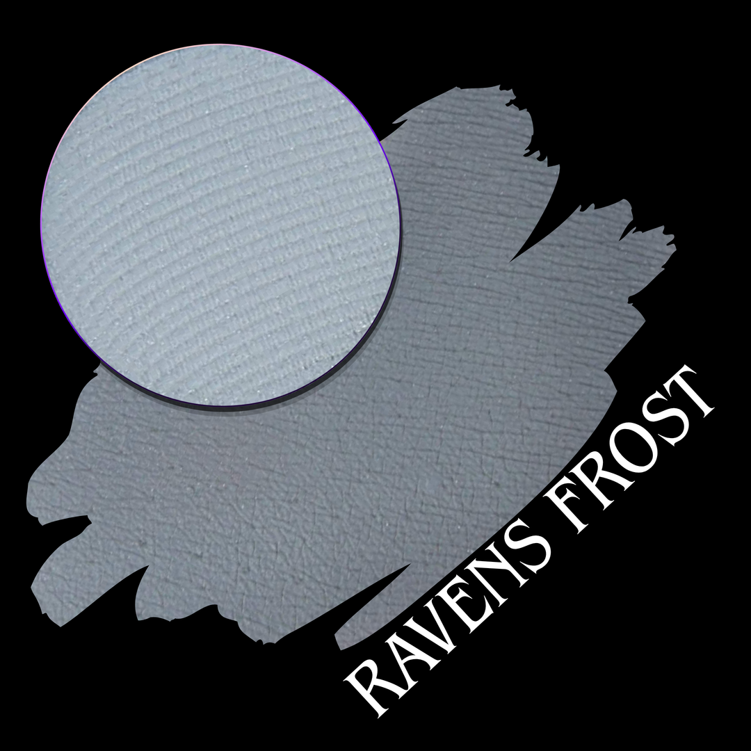 A textured light gray swatch with a circular close-up of an eyeshadow pressed powder pan on a black background, labeled 'RAVENS FROST' in white text.