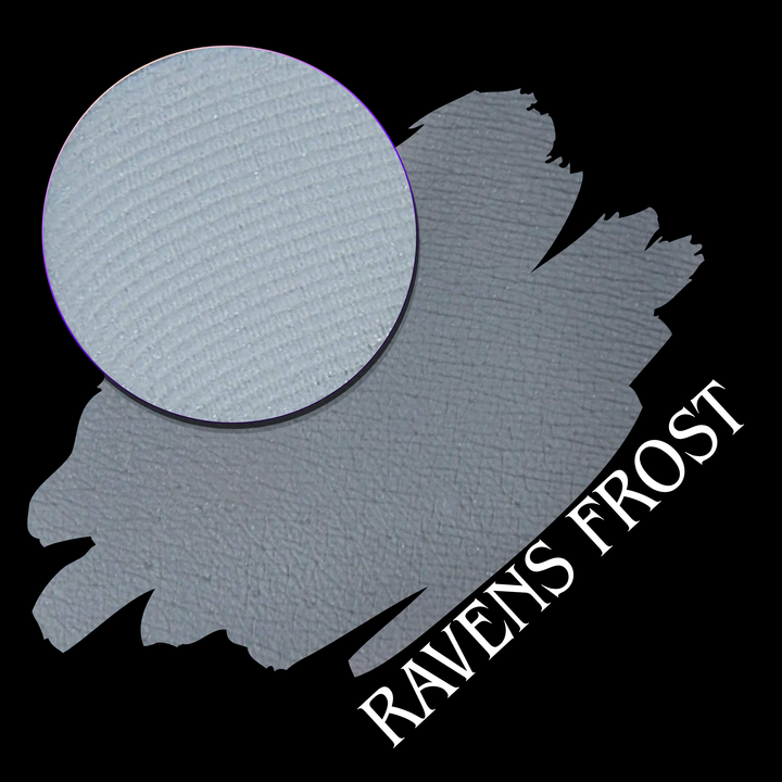 A textured light gray swatch with a circular close-up of an eyeshadow pressed powder pan on a black background, labeled 'RAVENS FROST' in white text.