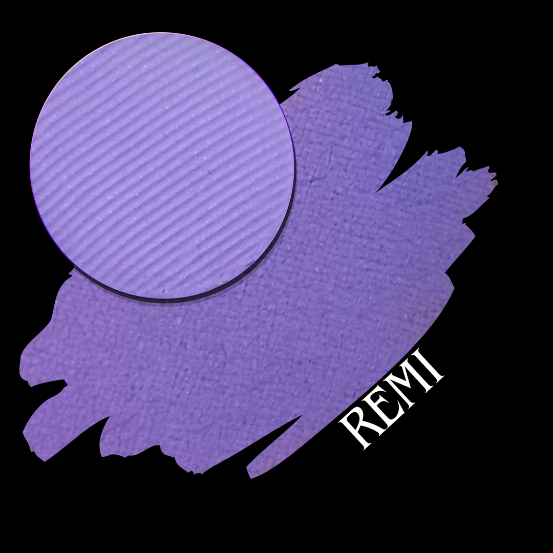 A circular eyeshadow makeup pan in a lavender-purple shade is shown over a matching purple swatch on a black background, with the text 'REMI' in white at the lower right.