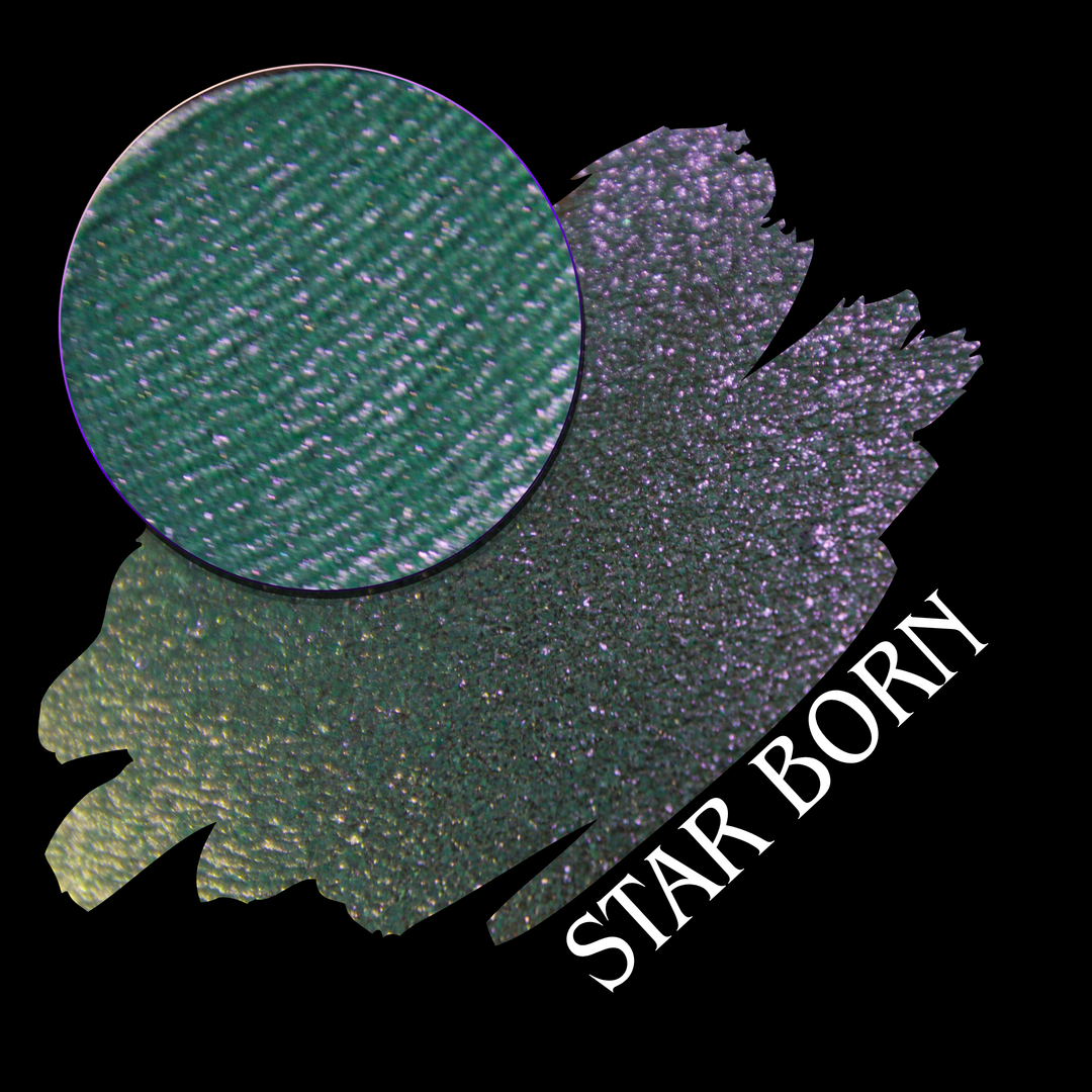 A product color swatch showing a shimmering eyeshadow with a circular makeup pan on a black background. The color shifts between green, gold, and purple, with the text 'STAR BORN' written diagonally made by Devinah Cosmetics.