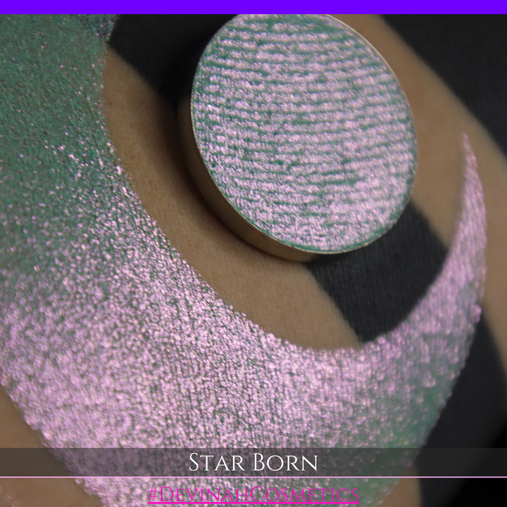 A close-up of a person's skin with a large iridescent crescent moon makeup swatch and a matching circular eyeshadow pan in the center. The text 'STAR BORN' and 'Devinah Cosmetics' appears at the bottom.