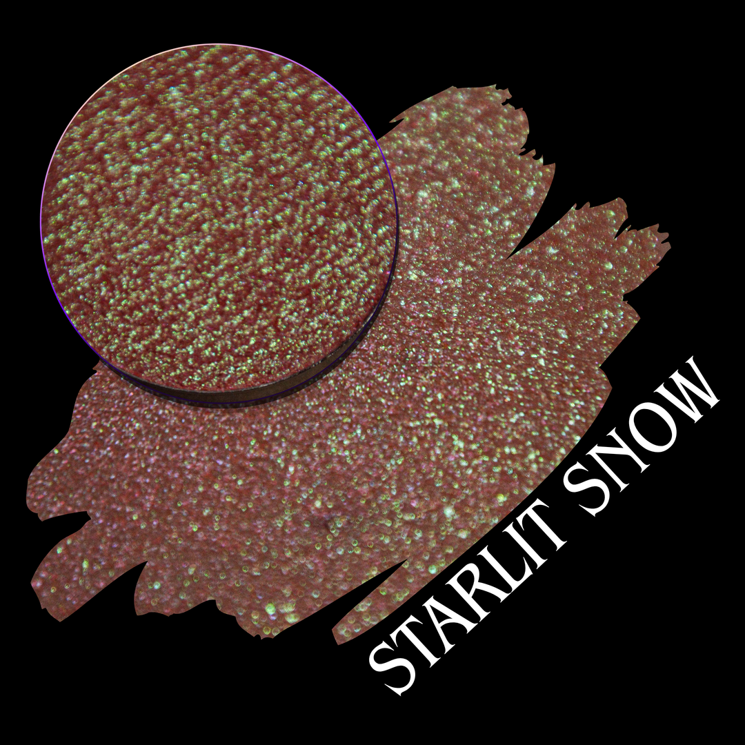 A close-up circular eyeshadow pan with a swatch of the makeup in the shade name 'STARLIT SNOW' on a black background. The color reads as a warm rosy copper-brown with dense iridescent sparkle.