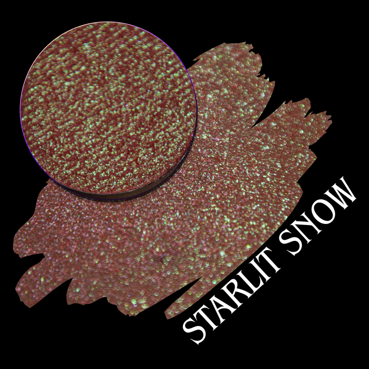 A close-up circular eyeshadow pan with a swatch of the makeup in the shade name 'STARLIT SNOW' on a black background. The color reads as a warm rosy copper-brown with dense iridescent sparkle.