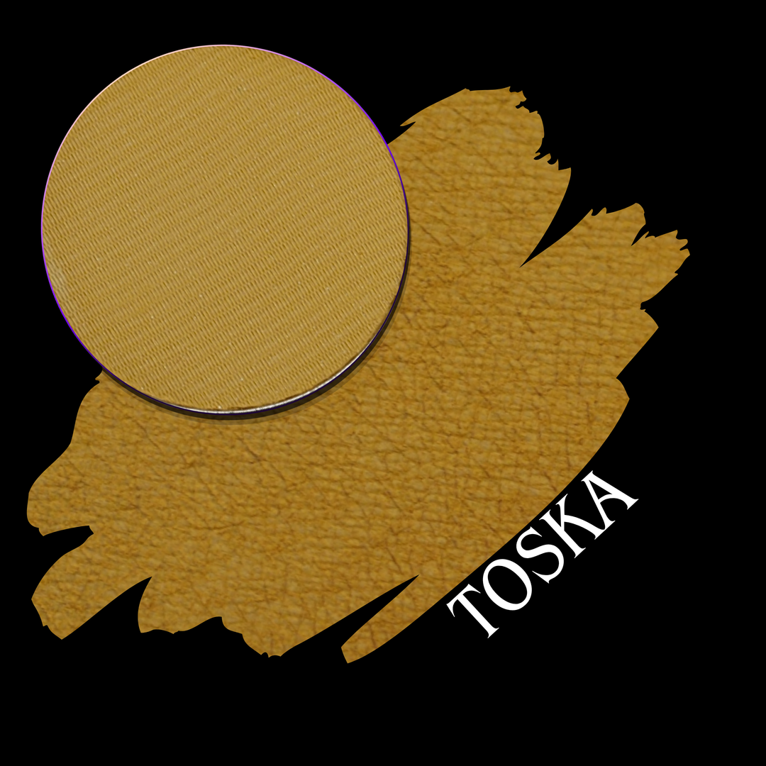 A golden yellow swatch with a circular eyeshadow pan of matte pigment, labeled 'TOSKA' on a black background.