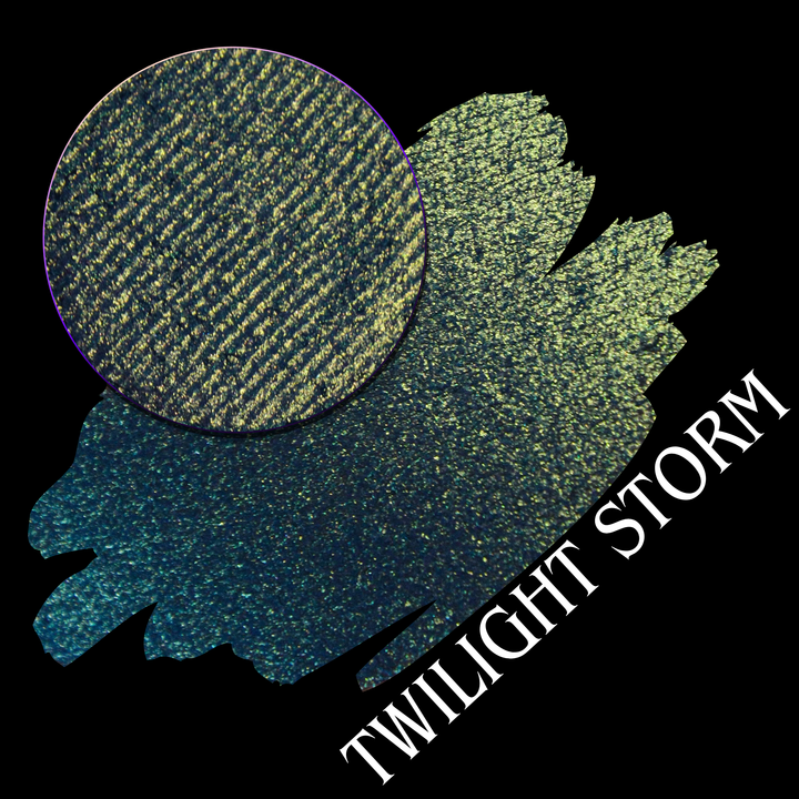 An eyeshadow swatch in a blue-to-yellow gradient with a circular eyeshadow pan, labeled 'TWILIGHT STORM' on a black background handmade by Devinah Cosmetics.