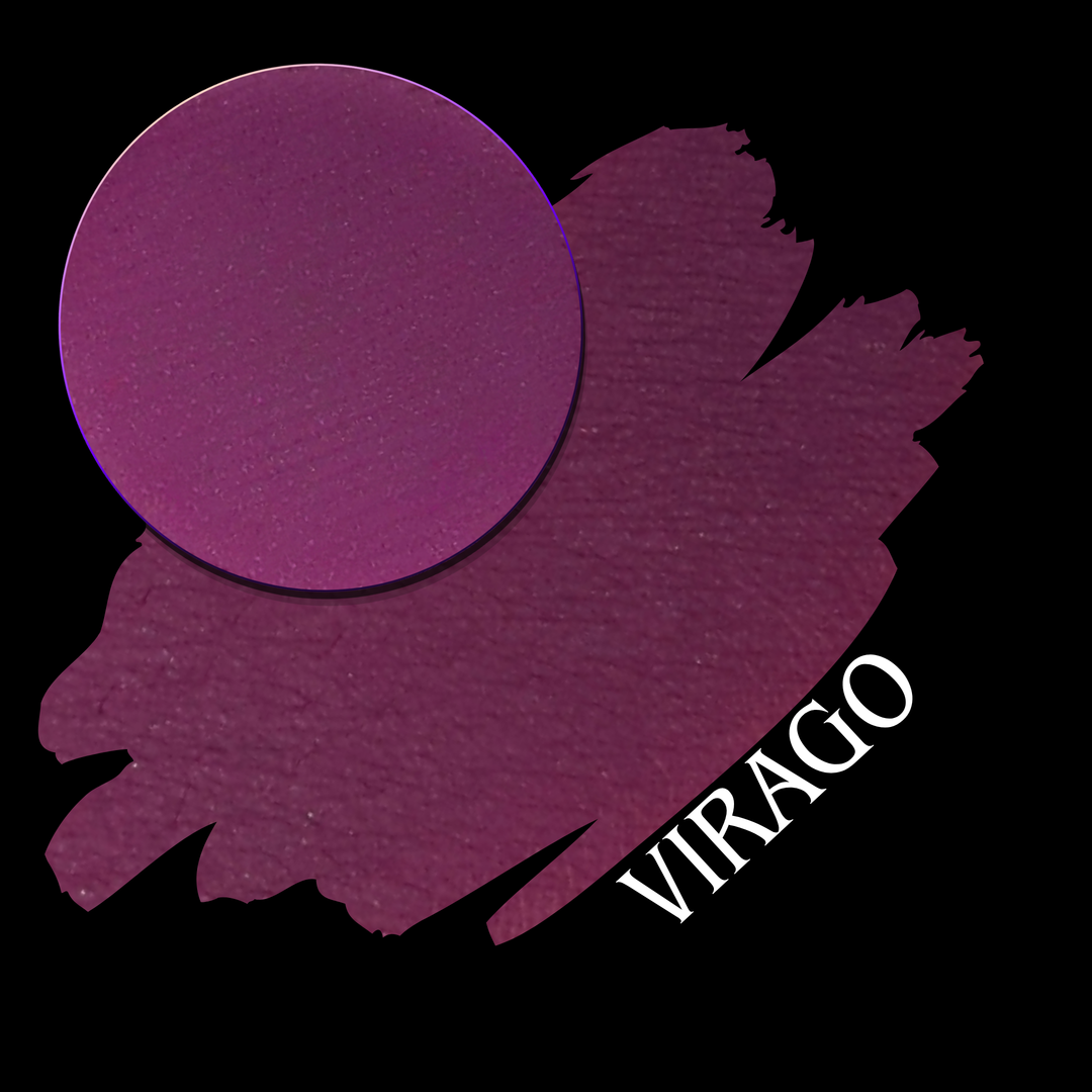 A circular makeup pan in a deep berry purple shade shown next to a  swatch of the same color on a black background, with the word 'VIRAGO' in white text.