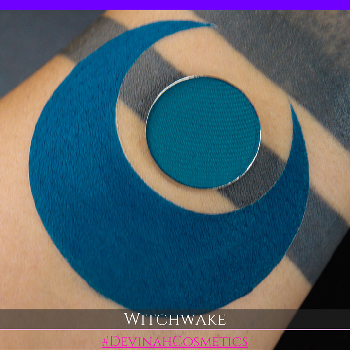 A close-up an eyeshadow swatch, plus a small round teal makeup pan placed over the center. Text at the bottom reads 'WITCHWAKE' and '#DEVINAHCOSMETICS'.