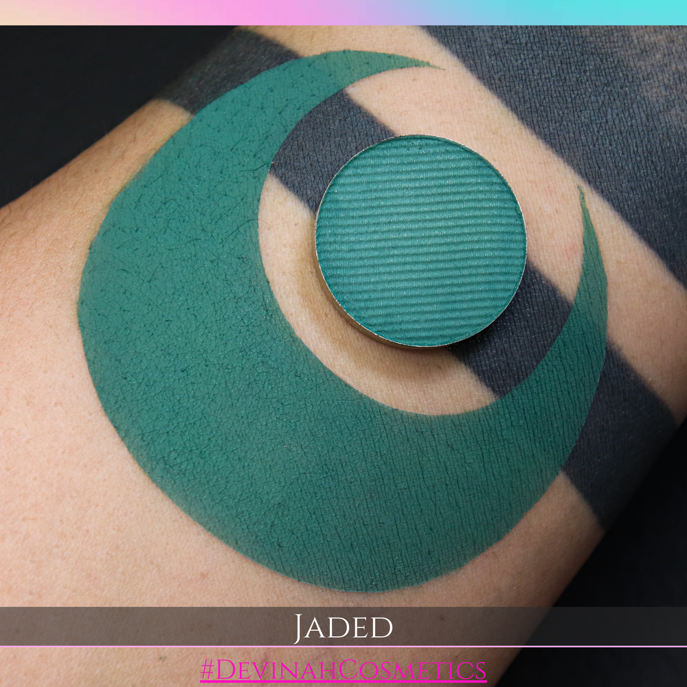 Green eyeshadow makeup pan on a person's arm with 'Jaded' and '#DevinahCosmetics' branding.