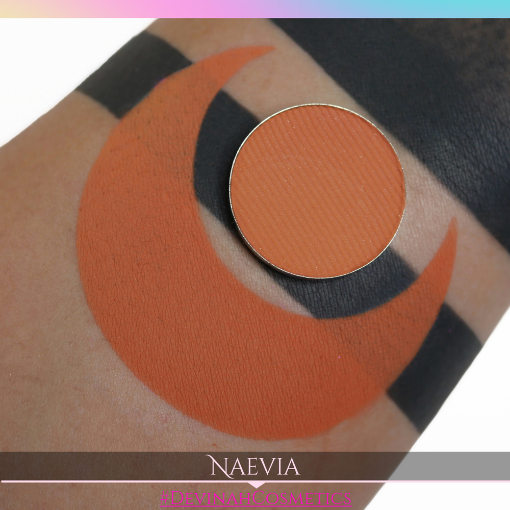 Orange makeup swatch on skin with 'Naevia' branding