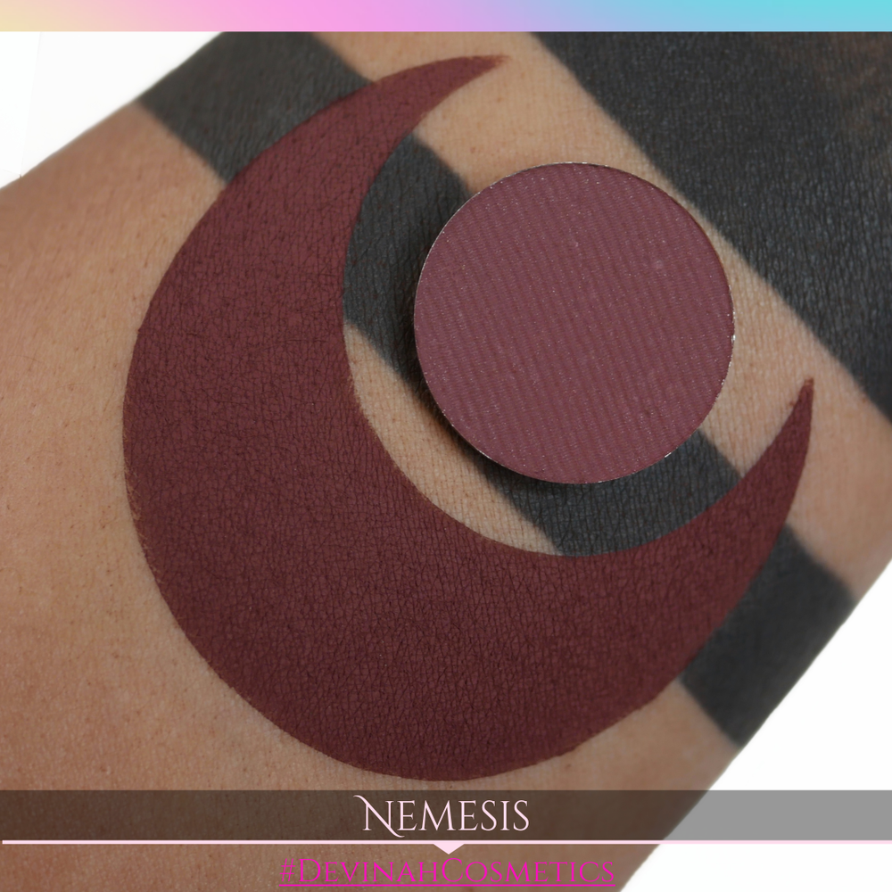 Makeup product with circular design on a skin-like background, featuring the brand 'Nemesis'.