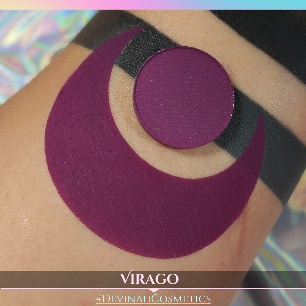 Purple swatch on skin showing eyeshadow pan with 'VIRAGO' and '#DEVINAH COSMETICS' branding.